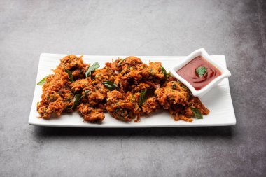 Havuçlu börek veya Gajar ke pakore veya pakode veya bajji veya bhaji, Hint aperatifi domates ketçaplı bir tabakta servis edilir.