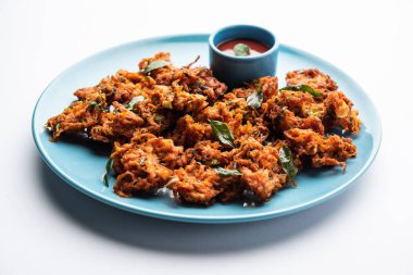 Havuçlu börek veya Gajar ke pakore veya pakode veya bajji veya bhaji, Hint aperatifi domates ketçaplı bir tabakta servis edilir.