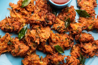 Havuçlu börek veya Gajar ke pakore veya pakode veya bajji veya bhaji, Hint aperatifi domates ketçaplı bir tabakta servis edilir.