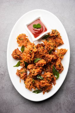 Carrot Fritters or Gajar ke pakore or pakode or bajji or bhaji, Indian snack served in a plate with tomato ketchup clipart