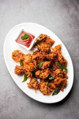 Havuçlu börek veya Gajar ke pakore veya pakode veya bajji veya bhaji, Hint aperatifi domates ketçaplı bir tabakta servis edilir.