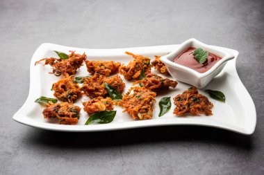 Havuçlu börek veya Gajar ke pakore veya pakode veya bajji veya bhaji, Hint aperatifi domates ketçaplı bir tabakta servis edilir.