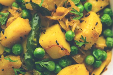 Aloo Mutter veya Matar aalu dry sabzi, Hint Patatesi ve yeşil bezelyeler baharatla kızartılmış ve kişniş yapraklarıyla süslenmiş. Roti veya chapati ile servis edilir.