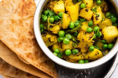 Aloo Mutter veya Matar aalu dry sabzi, Hint Patatesi ve yeşil bezelyeler baharatla kızartılmış ve kişniş yapraklarıyla süslenmiş. Roti veya chapati ile servis edilir.