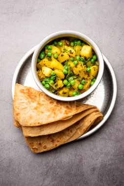 Aloo Mutter veya Matar aalu dry sabzi, Hint Patatesi ve yeşil bezelyeler baharatla kızartılmış ve kişniş yapraklarıyla süslenmiş. Roti veya chapati ile servis edilir.