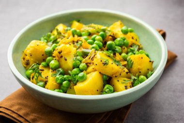 Aloo Mutter veya Matar aalu dry sabzi, Hint Patatesi ve yeşil bezelyeler baharatla kızartılmış ve kişniş yapraklarıyla süslenmiş. Roti veya chapati ile servis edilir.