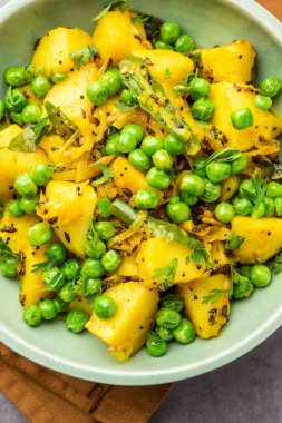 Aloo Mutter veya Matar aalu dry sabzi, Hint Patatesi ve yeşil bezelyeler baharatla kızartılmış ve kişniş yapraklarıyla süslenmiş. Roti veya chapati ile servis edilir.