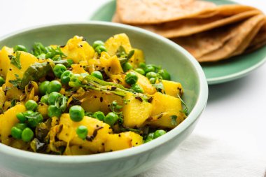 Aloo Mutter veya Matar aalu dry sabzi, Hint Patatesi ve yeşil bezelyeler baharatla kızartılmış ve kişniş yapraklarıyla süslenmiş. Roti veya chapati ile servis edilir.