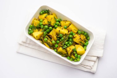 Aloo Mutter veya Matar aalu dry sabzi, Hint Patatesi ve yeşil bezelyeler baharatla kızartılmış ve kişniş yapraklarıyla süslenmiş. Roti veya chapati ile servis edilir.