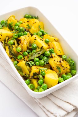 Aloo Mutter veya Matar aalu dry sabzi, Hint Patatesi ve yeşil bezelyeler baharatla kızartılmış ve kişniş yapraklarıyla süslenmiş. Roti veya chapati ile servis edilir.