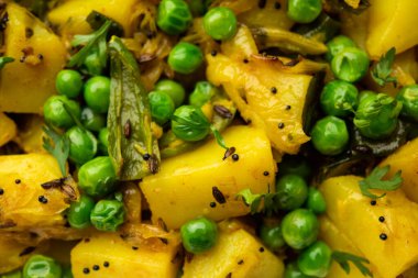 Aloo Mutter veya Matar aalu dry sabzi, Hint Patatesi ve yeşil bezelyeler baharatla kızartılmış ve kişniş yapraklarıyla süslenmiş. Roti veya chapati ile servis edilir.