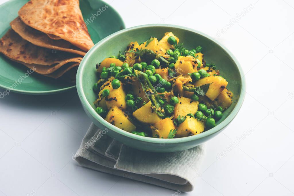 Aloo Mutter or Matar aalu dry sabzi, Indian Potato and green Peas fried together with spices and garnished with coriander leaves. served with roti or chapati