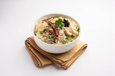 Lezzetli mantar veya mantarlı pilav veya Pulav veya Pilaf veya Pulao veya Biryani bir kase veya tabakta servis edilir, seçici bir odaklanma