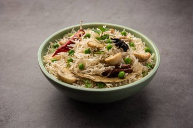 Lezzetli mantar veya mantarlı pilav veya Pulav veya Pilaf veya Pulao veya Biryani bir kase veya tabakta servis edilir, seçici bir odaklanma