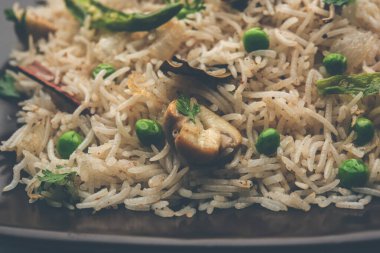 Lezzetli mantar veya mantarlı pilav veya Pulav veya Pilaf veya Pulao veya Biryani bir kase veya tabakta servis edilir, seçici bir odaklanma