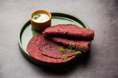 Beetroot paratha or Roti is an Indian whole wheat flatbread stuffed with a spiced chukandar filling, served with curd clipart