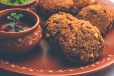 Masala Chana Dal Vada veya Parippu veya Paruppu Vadai, Maharashtra ve Kerala 'dan alınmış bir çerez tarifi. Tabakta servis ediliyor. seçici odak
