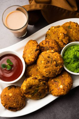 Masala Chana Dal Vada veya Parippu veya Paruppu Vadai, Maharashtra ve Kerala 'dan alınmış bir çerez tarifi. Tabakta servis ediliyor. seçici odak