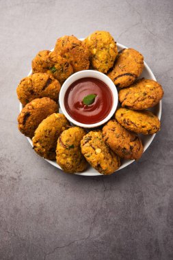 Masala Chana Dal Vada veya Parippu veya Paruppu Vadai, Maharashtra ve Kerala 'dan alınmış bir çerez tarifi. Tabakta servis ediliyor. seçici odak