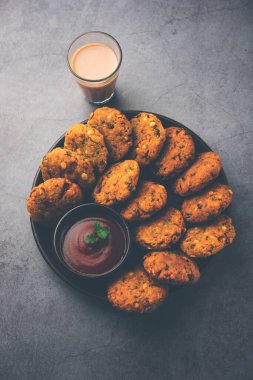 Masala Chana Dal Vada veya Parippu veya Paruppu Vadai, Maharashtra ve Kerala 'dan alınmış bir çerez tarifi. Tabakta servis ediliyor. seçici odak
