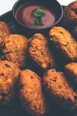 Masala Chana Dal Vada veya Parippu veya Paruppu Vadai, Maharashtra ve Kerala 'dan alınmış bir çerez tarifi. Tabakta servis ediliyor. seçici odak