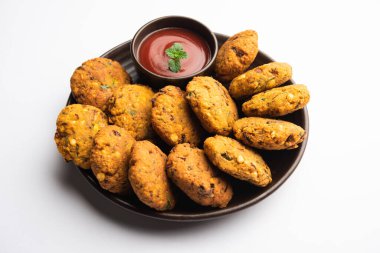 Masala Chana Dal Vada veya Parippu veya Paruppu Vadai, Maharashtra ve Kerala 'dan alınmış bir çerez tarifi. Tabakta servis ediliyor. seçici odak
