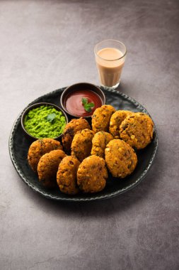 Masala Chana Dal Vada veya Parippu veya Paruppu Vadai, Maharashtra ve Kerala 'dan alınmış bir çerez tarifi. Tabakta servis ediliyor. seçici odak