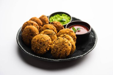 Masala Chana Dal Vada veya Parippu veya Paruppu Vadai, Maharashtrian ve Kerala 'dan alınmış bir çerez tarifi. Tabakta servis ediliyor. seçici odak