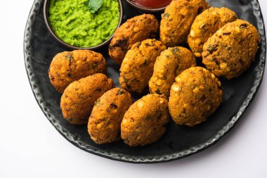Masala Chana Dal Vada veya Parippu veya Paruppu Vadai, Maharashtrian ve Kerala 'dan alınmış bir çerez tarifi. Tabakta servis ediliyor. seçici odak
