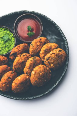 Masala Chana Dal Vada veya Parippu veya Paruppu Vadai, Maharashtrian ve Kerala 'dan alınmış bir çerez tarifi. Tabakta servis ediliyor. seçici odak