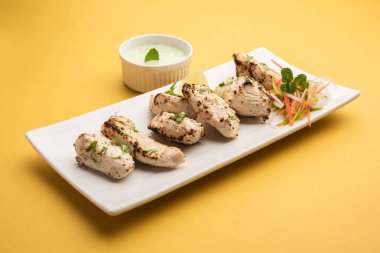 Hint Afgan tavuğu Malai Tikka taze salatayla servis edilen ızgara Murgh kremalı kebaptır.