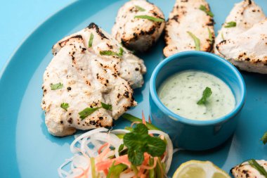 Hint Afgan tavuğu Malai Tikka taze salatayla servis edilen ızgara Murgh kremalı kebaptır.