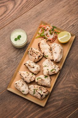 Hint Afgan tavuğu Malai Tikka taze salatayla servis edilen ızgara Murgh kremalı kebaptır.