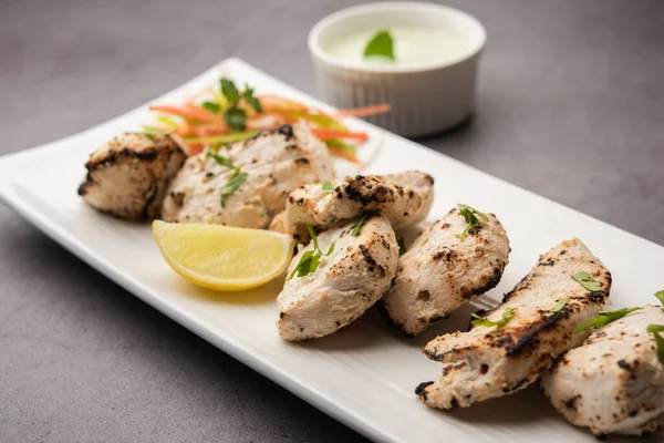 Hint Afgan tavuğu Malai Tikka taze salatayla servis edilen ızgara Murgh kremalı kebaptır.