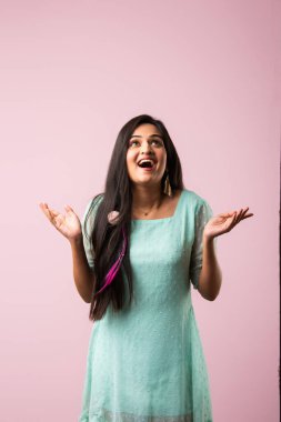 Hintli güzel kız ya da genç kadının üzerine pembe arka planda parıltı düşüyor.