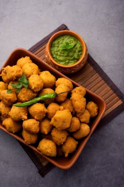 Muson Özel Moong Dal Vada, Pakoda, Dalwada, Pakora veya Mungdal Bhajiya veya Yeşil Chutney ile servis edilen Sarı Börek. seçici odak