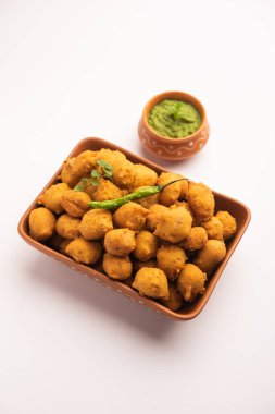 Muson Özel Moong Dal Vada, Pakoda, Dalwada, Pakora veya Mungdal Bhajiya veya Yeşil Chutney ile servis edilen Sarı Börek. seçici odak