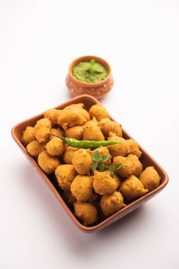 Muson Özel Moong Dal Vada, Pakoda, Dalwada, Pakora veya Mungdal Bhajiya veya Yeşil Chutney ile servis edilen Sarı Börek. seçici odak