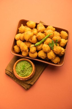 Muson Özel Moong Dal Vada, Pakoda, Dalwada, Pakora veya Mungdal Bhajiya veya Yeşil Chutney ile servis edilen Sarı Börek. seçici odak