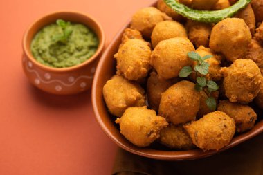 Muson Özel Moong Dal Vada, Pakoda, Dalwada, Pakora veya Mungdal Bhajiya veya Yeşil Chutney ile servis edilen Sarı Börek. seçici odak