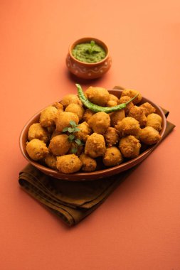 Muson Özel Moong Dal Vada, Pakoda, Dalwada, Pakora veya Mungdal Bhajiya veya Yeşil Chutney ile servis edilen Sarı Börek. seçici odak