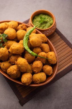 Muson Özel Moong Dal Vada, Pakoda, Dalwada, Pakora veya Mungdal Bhajiya veya Yeşil Chutney ile servis edilen Sarı Börek. seçici odak