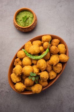 Muson Özel Moong Dal Vada, Pakoda, Dalwada, Pakora veya Mungdal Bhajiya veya Yeşil Chutney ile servis edilen Sarı Börek. seçici odak