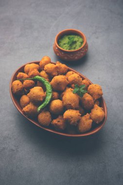 Muson Özel Moong Dal Vada, Pakoda, Dalwada, Pakora veya Mungdal Bhajiya veya Yeşil Chutney ile servis edilen Sarı Börek. seçici odak