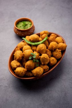 Muson Özel Moong Dal Vada, Pakoda, Dalwada, Pakora veya Mungdal Bhajiya veya Yeşil Chutney ile servis edilen Sarı Börek. seçici odak