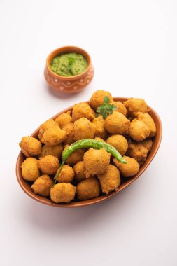Muson Özel Moong Dal Vada, Pakoda, Dalwada, Pakora veya Mungdal Bhajiya veya Yeşil Chutney ile servis edilen Sarı Börek. seçici odak