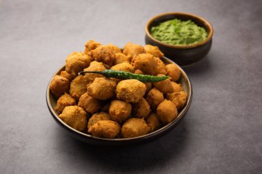 Muson Özel Moong Dal Vada, Pakoda, Dalwada, Pakora veya Mungdal Bhajiya veya Yeşil Chutney ile servis edilen Sarı Börek. seçici odak