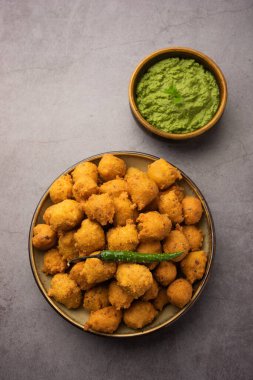 Muson Özel Moong Dal Vada, Pakoda, Dalwada, Pakora veya Mungdal Bhajiya veya Yeşil Chutney ile servis edilen Sarı Börek. seçici odak