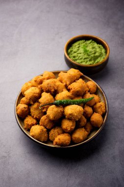 Muson Özel Moong Dal Vada, Pakoda, Dalwada, Pakora veya Mungdal Bhajiya veya Yeşil Chutney ile servis edilen Sarı Börek. seçici odak
