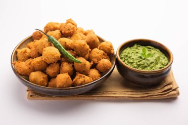 Muson Özel Moong Dal Vada, Pakoda, Dalwada, Pakora veya Mungdal Bhajiya veya Yeşil Chutney ile servis edilen Sarı Börek. seçici odak